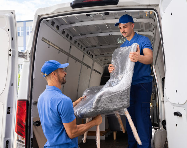 Zwei Entrümpelungsprofis laden einen verpackten Stuhl aus einem Transporter – effiziente Möbelentsorgung und Entrümpelungsdienst.